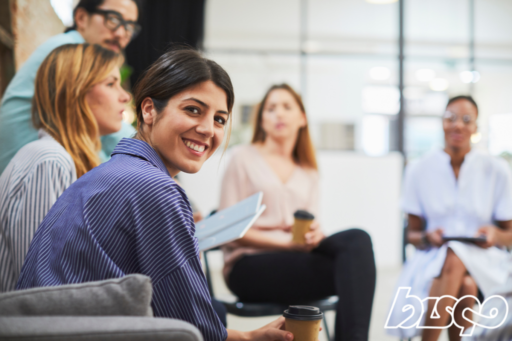 Människor som sitter i ett möte och delar med sig av nyheter och event över en kopp kaffe