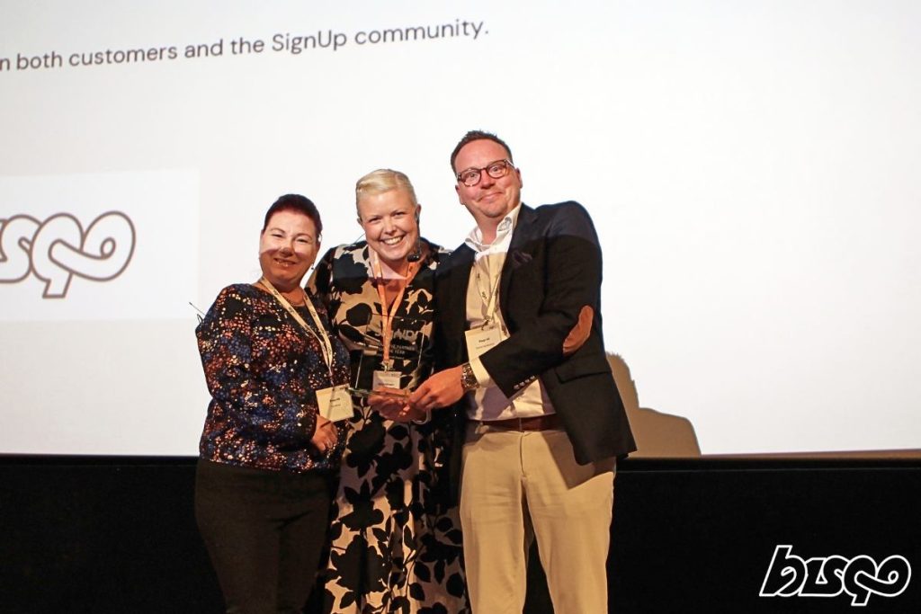 Pia Härsjö och Daniel Westerberg från Bisqo står tillsammans med Camilla Gustafsson från Signup på scen.